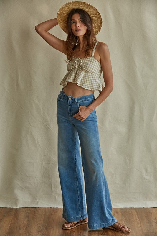 a woman standing on a wooden floor wearing a straw hat