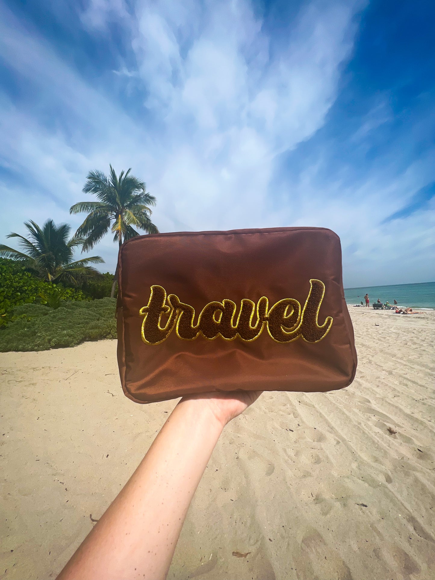a hand holding a bag with the word travel written on it