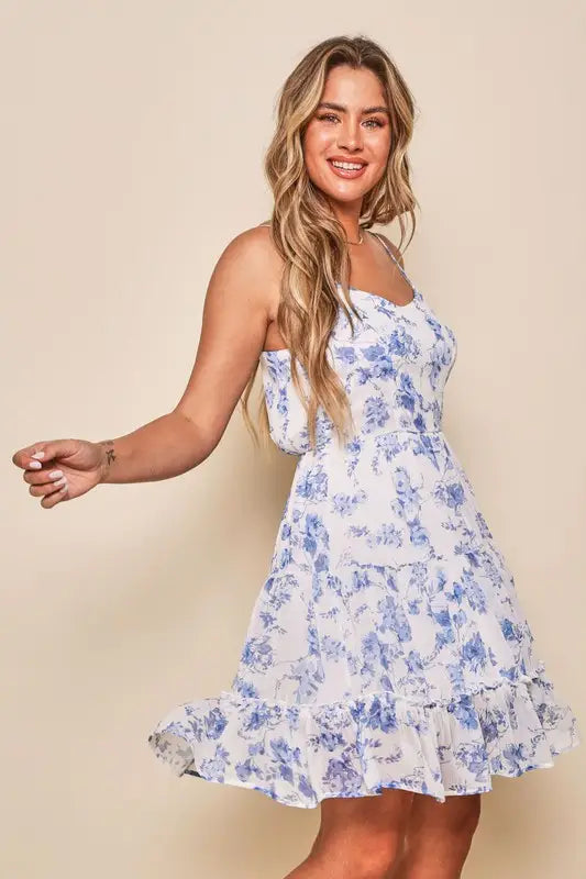 a woman posing in a blue and white dress