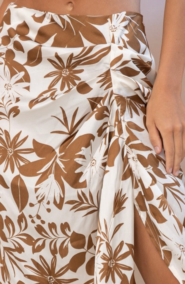 a woman wearing a skirt with a flower print on it